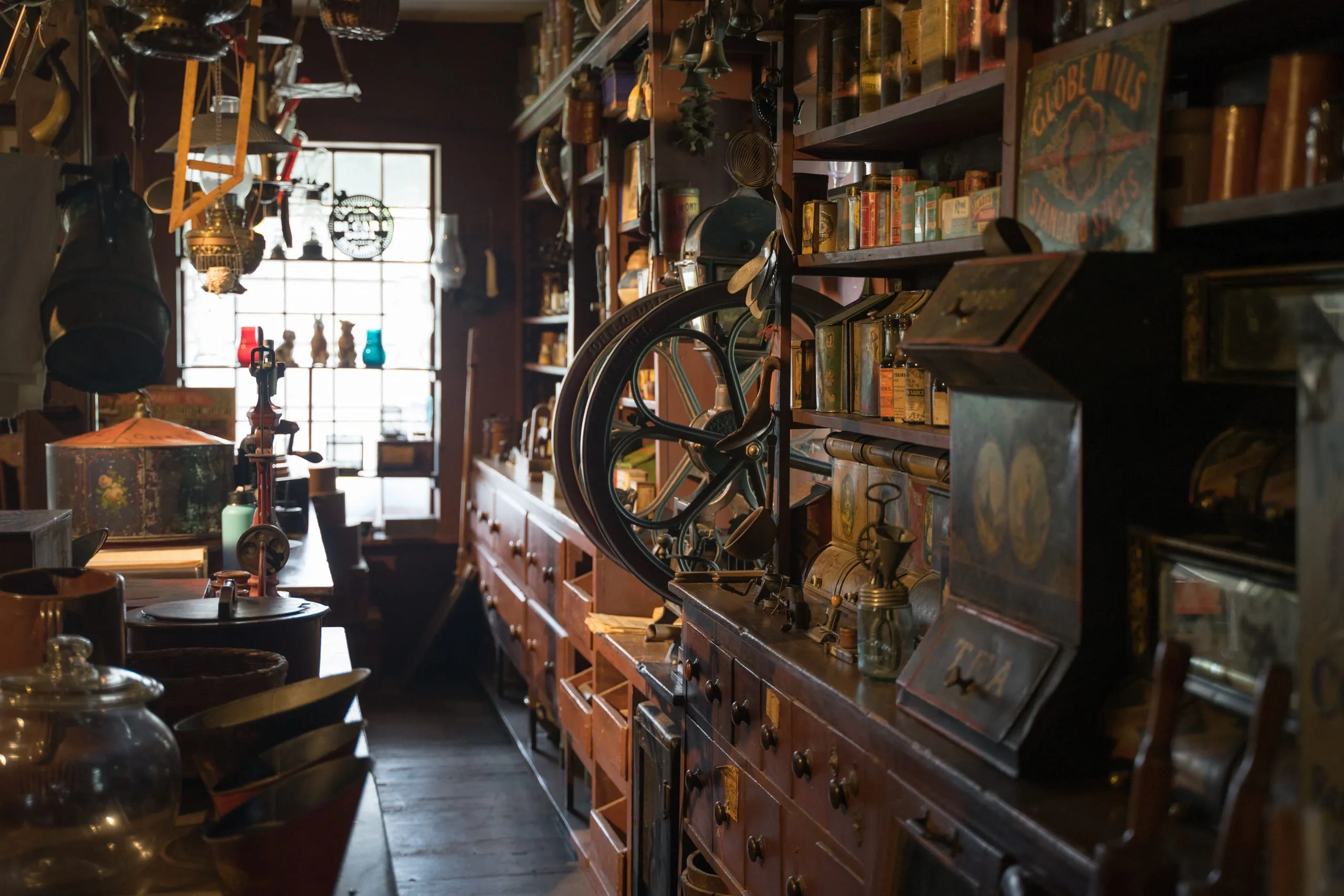 Cluttered interior of a vintage Vermont general store crowded with old tins, drawers, and a coffee grinder.