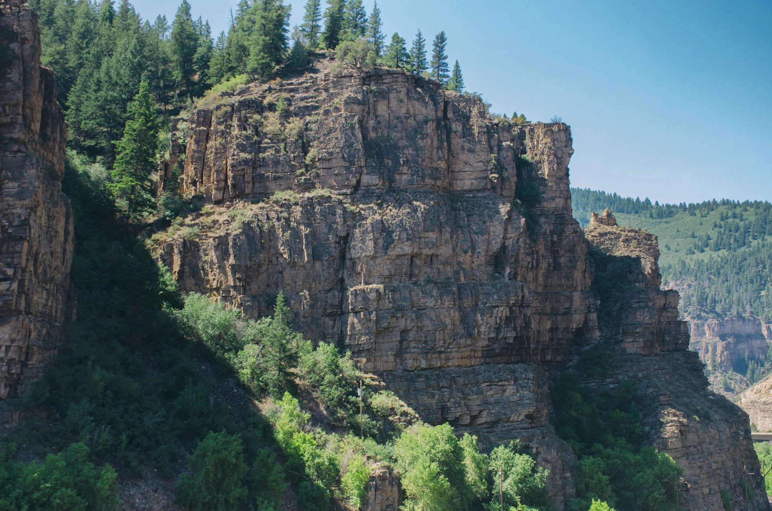 Columnar basalt cliff rising above a river in Colorado
