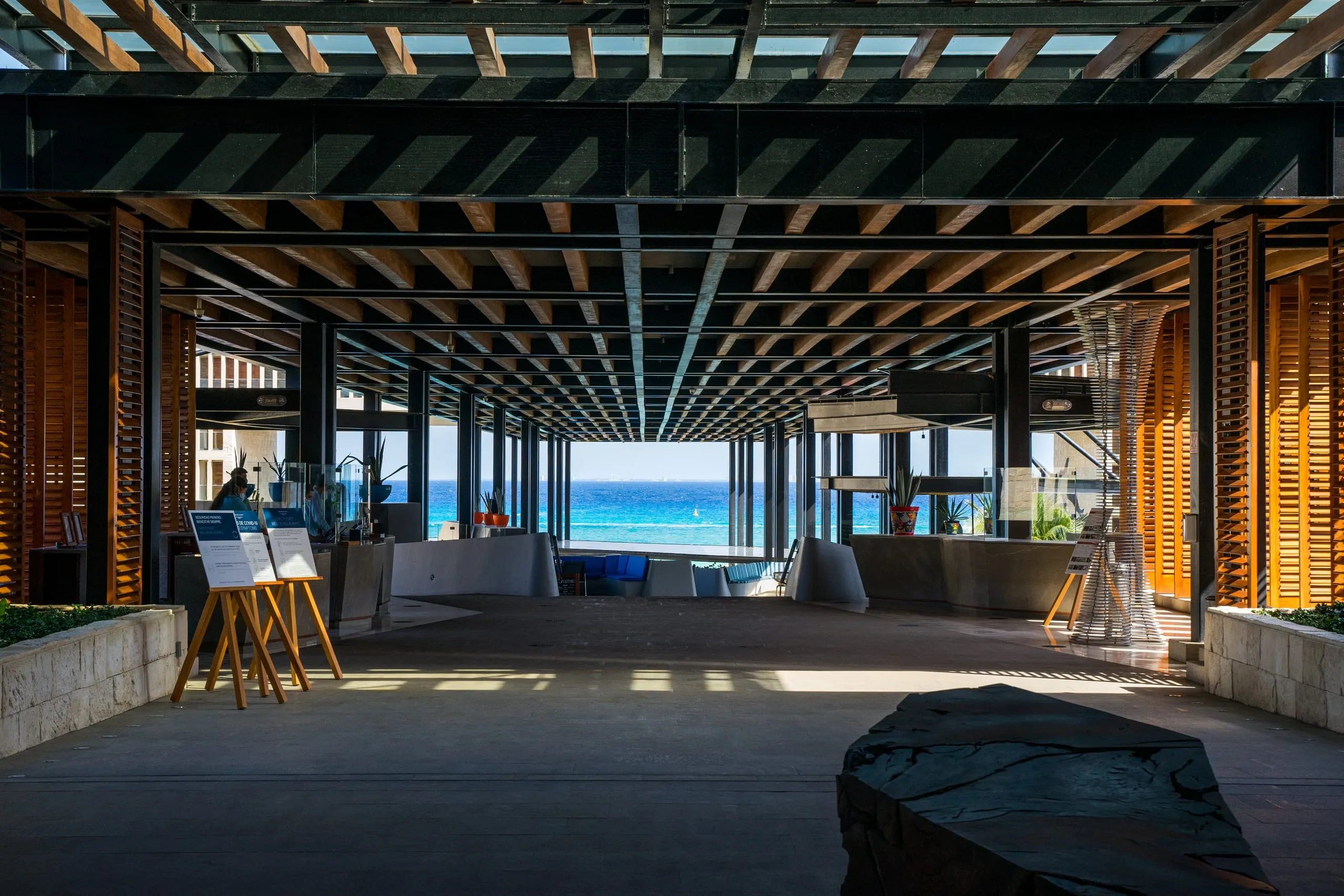Wood-slatted beach-club interior opening onto the turquoise Caribbean, Playa del Carmen