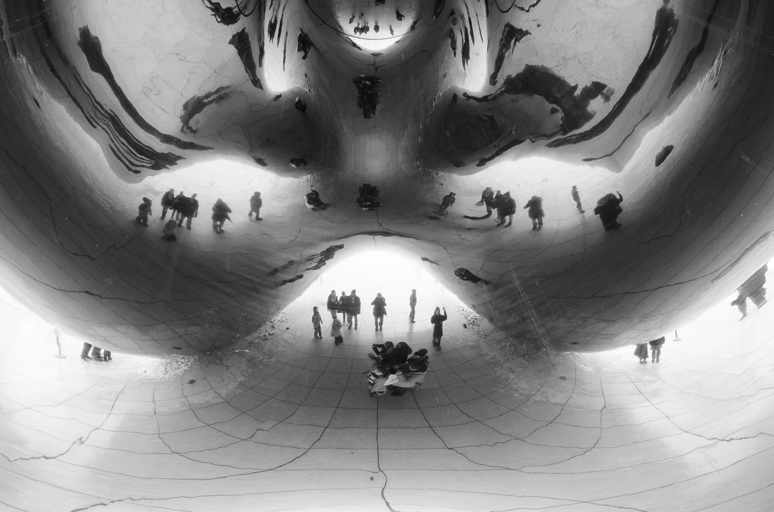 Black and white view up into the mirrored vortex beneath Cloud Gate in Chicago