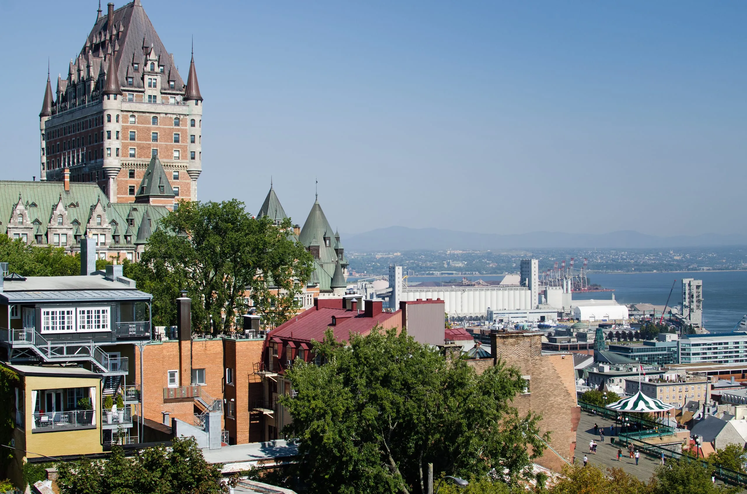 The turreted Chateau Frontenac towers over old Quebec City rooftops with the St. Lawrence River beyond.