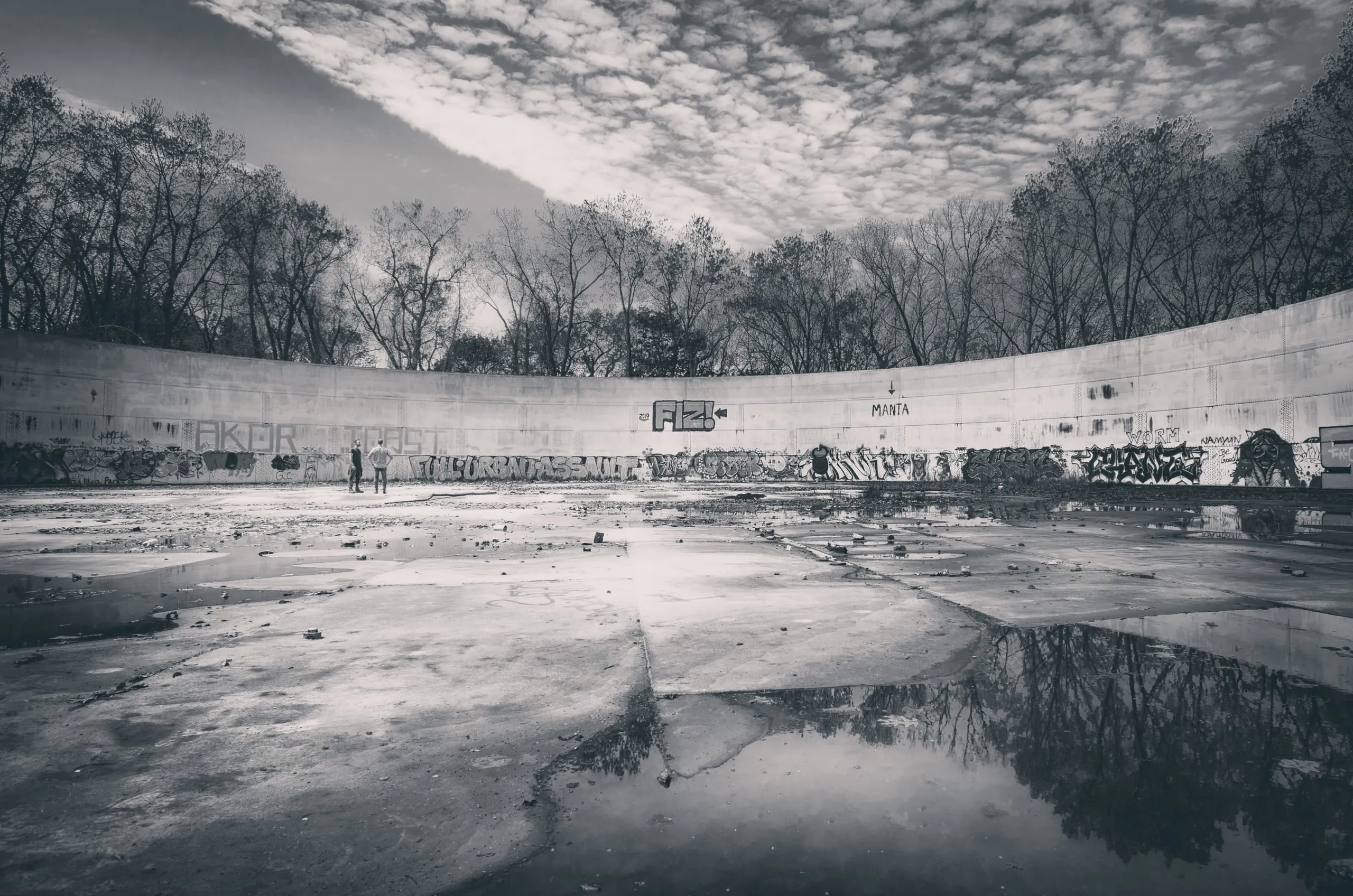 Black and white panorama of a frozen river basin curving under a mackerel sky